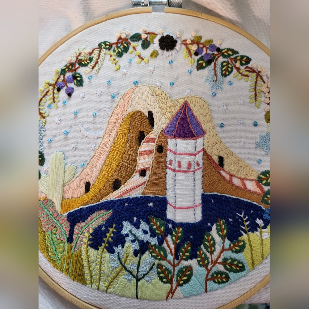 Colorful Embroidered Wall Art with Mountain and Tower Scene